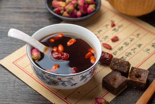 Brown sugar ginger jujube tea and Chinese classical medical books on the table