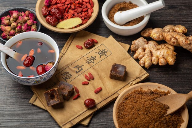 Brown sugar ginger jujube tea and Chinese classical medical books on the table