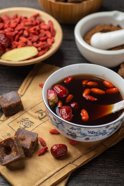 Brown sugar ginger jujube tea and Chinese classical medical books on the table