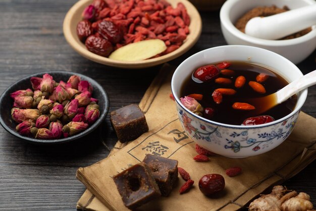 Brown sugar ginger jujube tea and Chinese classical medical books on the table