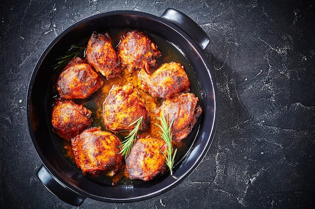 Brown Sugar Mustard Chicken thighs in a baking dish on a concrete table, horizontal view from above