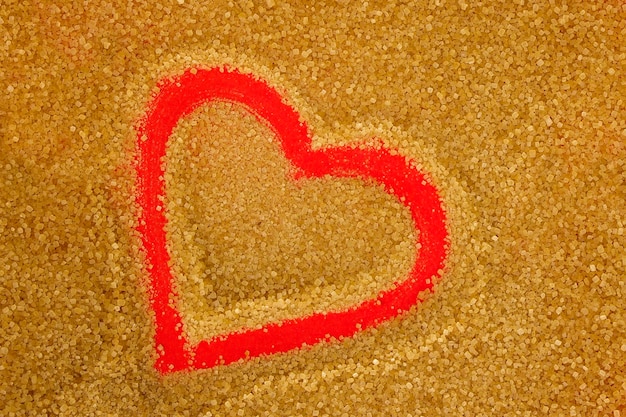 Brown sugar with red colour shape of heart as background Top view