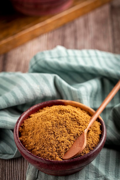 Brown sugar in wooden bowl on the table