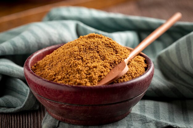 Brown sugar in wooden bowl on the table