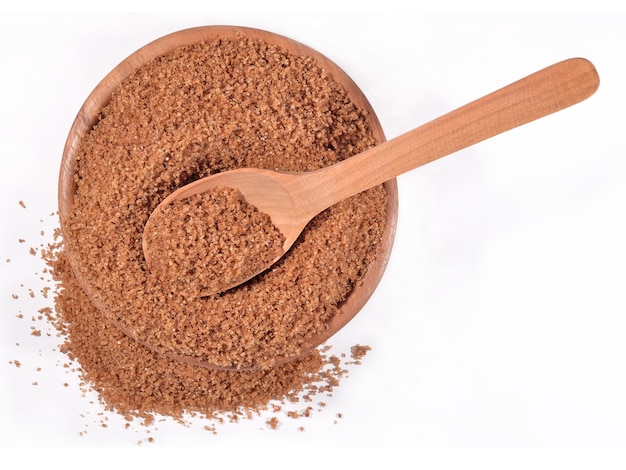 Brown sugar in a wooden bowl on a white background