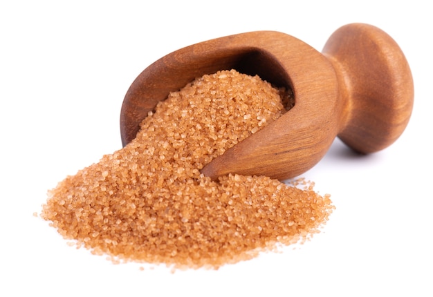 Brown sugar in wooden scoop isolated on white background heap of cane sugar crystals