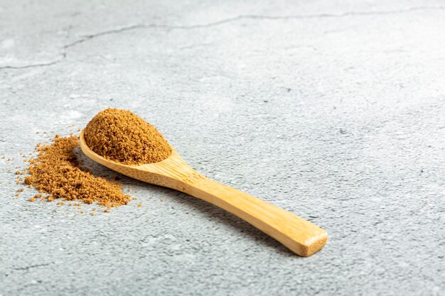 Brown sugar in wooden spoon on the table