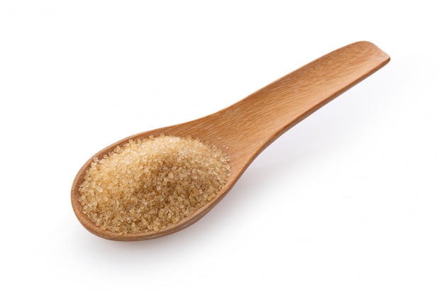 Brown sugar in wooden spoon on white wall