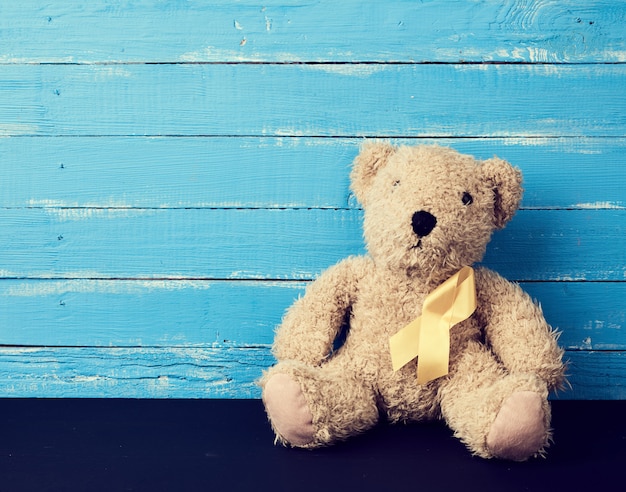 Brown teddy bear sits on a blue surface