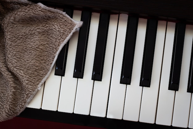 Brown towel on piano. 