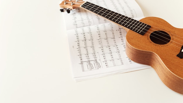 Brown ukulele guitar, sheet music. 