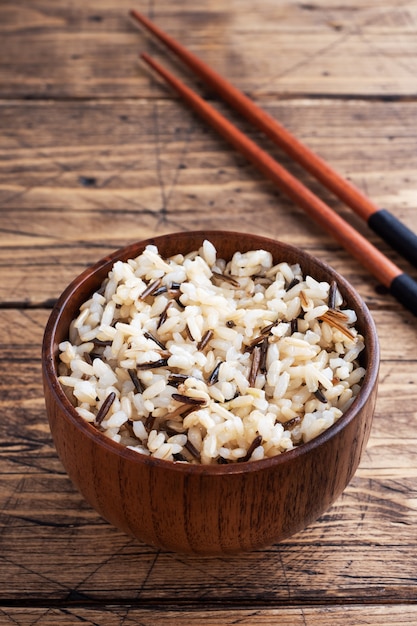 Brown and unpeeled rice on a plate with chopsticks.