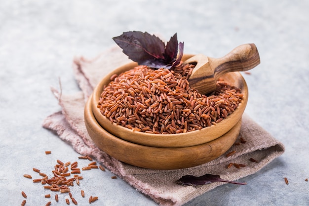 Brown unpolished rice in wooden bowl. long grain rice
background.