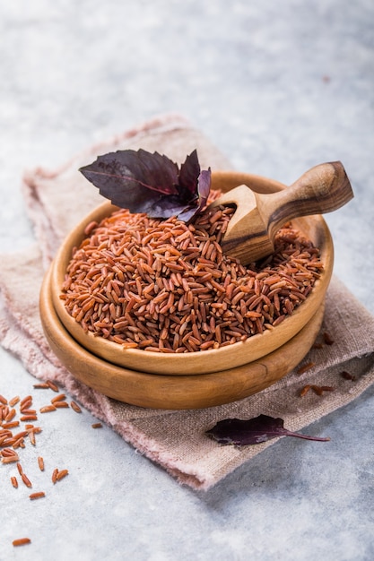 Brown Unpolished rice in wooden bowl. Long grain rice background.