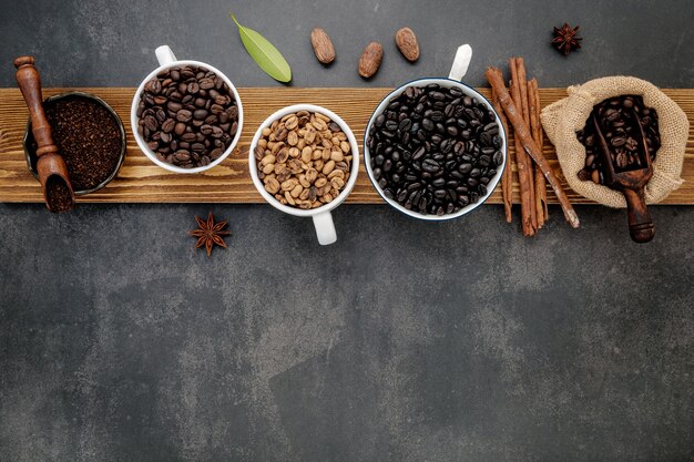 Brown unroasted and dark roasted coffee beans in coffee cup