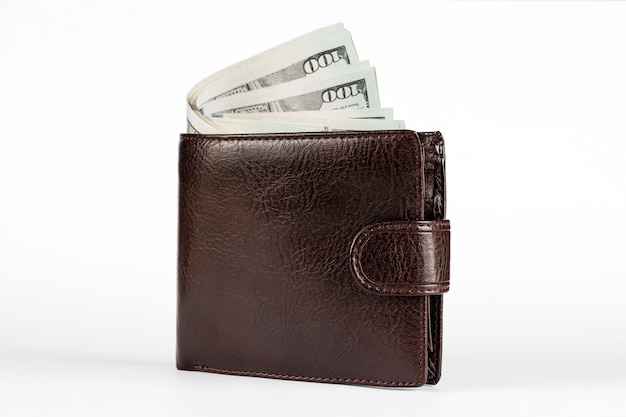 Photo brown wallet with dollars sticking out isolated on white