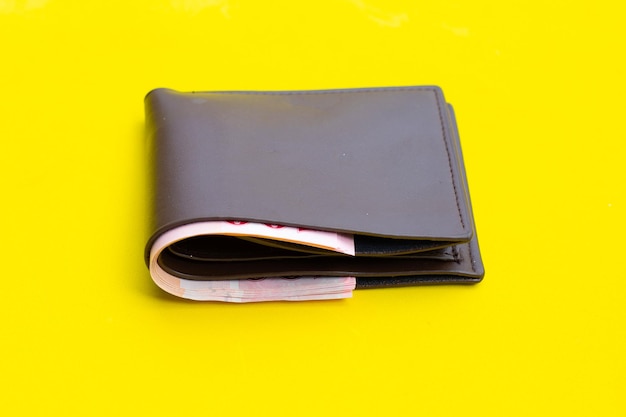 Brown wallet on yellow background