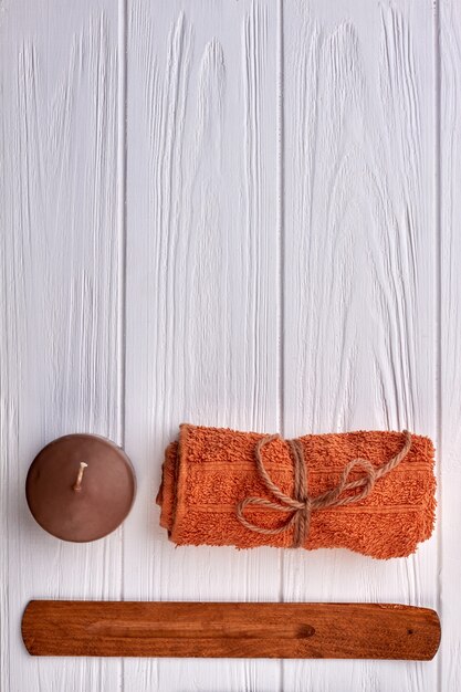 Brown with candle and towel on white wooden desk