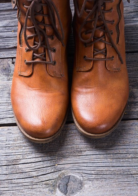 Brown women boots on a rustic wooden background