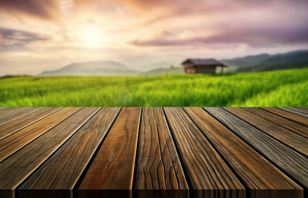 Brown wood table in summer farm green landscape.