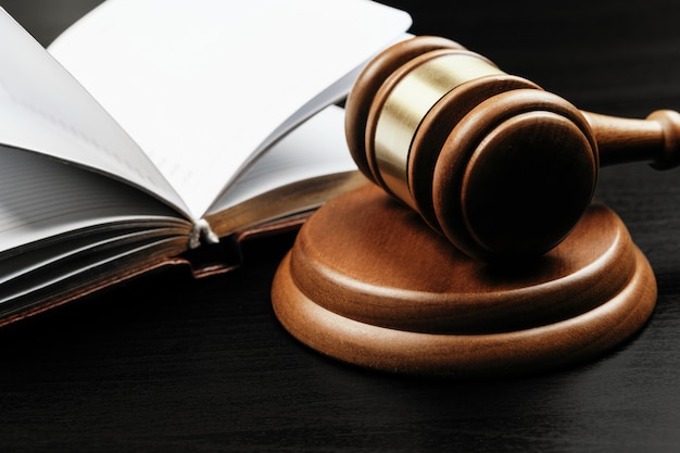 brown wooden judge mallet on the surface of open book