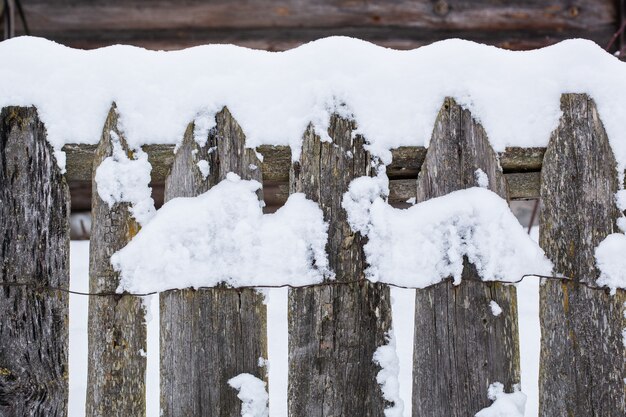 写真 雪に覆われた茶色の木の田舎の柵