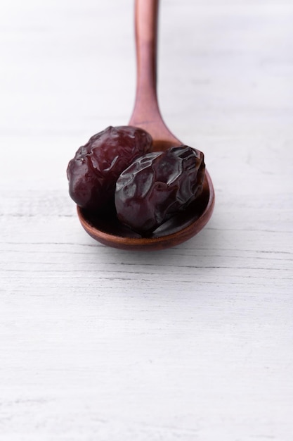 Brown wooden spoon with dates on white background for catalog