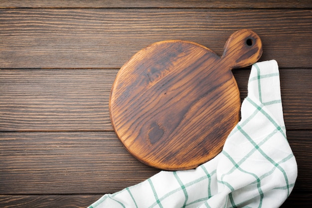 Brown wooden texture with old chopping board and wooden spoon. Background. Top view.