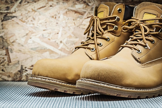 Brown working boots on plywood background