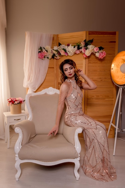 Browneyed brunette near the window  posing in a chair