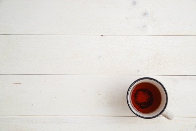 Brownie cake on a bamboo tray with cup of tea on a white wooden background with space for text