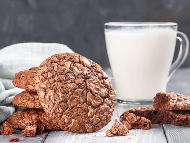 Brownie cookies on a wooden table with milk. Copy space.