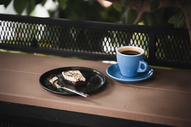 Brownie and hot coffee on wood bar