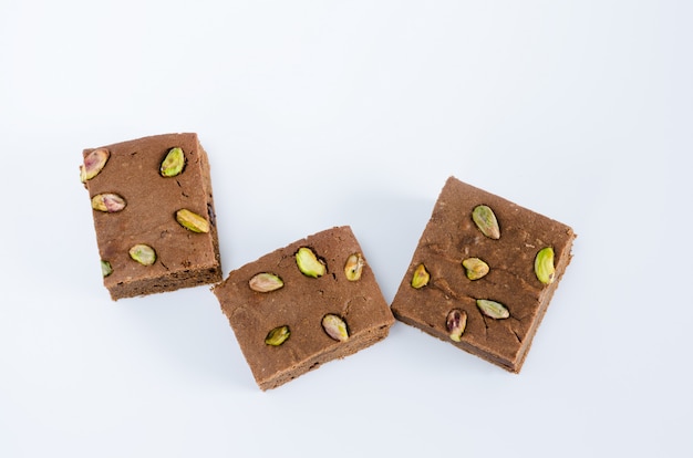 Brownie met pistachenoten op witte ondergrond