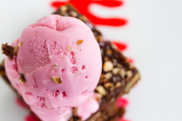 Brownie con salsa di ciliegie e cioccolato bianco e pallina di gelato sopra.