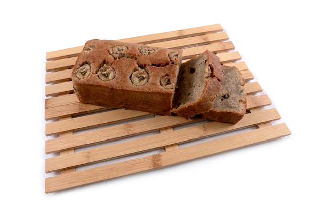 Brownies cake with choco banana flavor powdered by pieces of chocolate nut bar on a white background