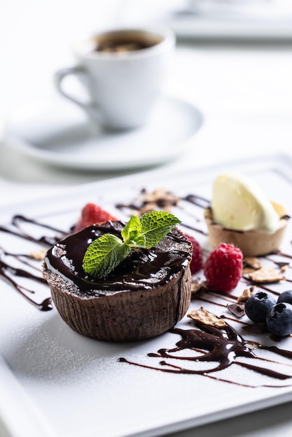 Foto brownies met ijs en fruit mint en chocolade decoratie met een espresso op een café tafel