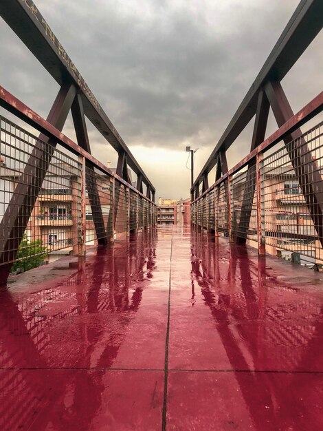 Foto brug door gebouwen in de stad tegen bewolkte lucht