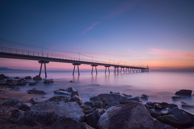 Brug op het strand bij zonsondergang