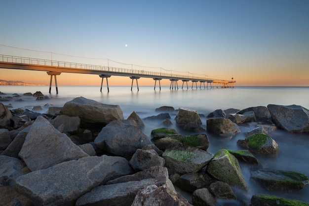 Brug op het strand bij zonsopgang