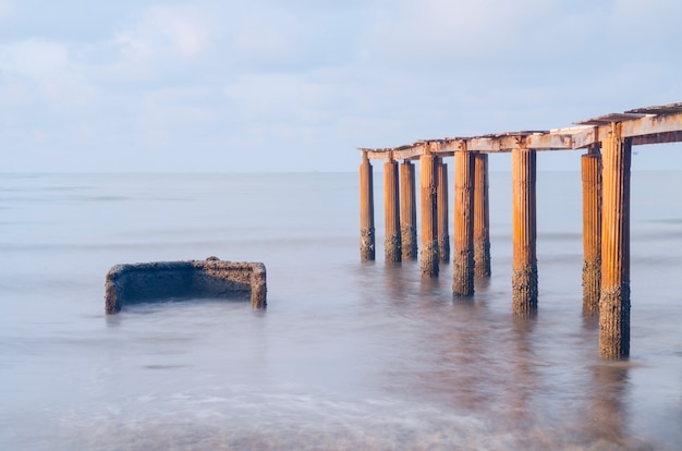 Brug op strand in zonsopgang en overzeese golf in Rayong, Thailand