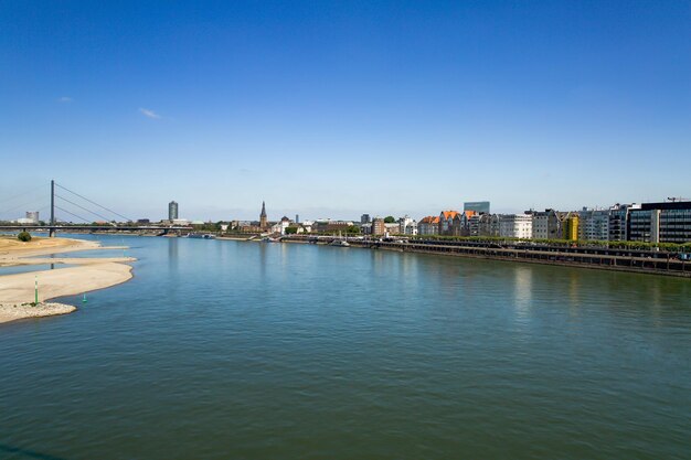 Brug over de rivier door gebouwen tegen een heldere blauwe hemel