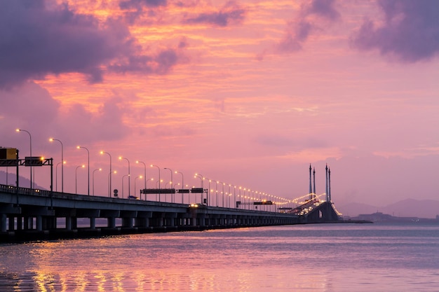 Foto brug over de rivier tegen de hemel bij zonsondergang