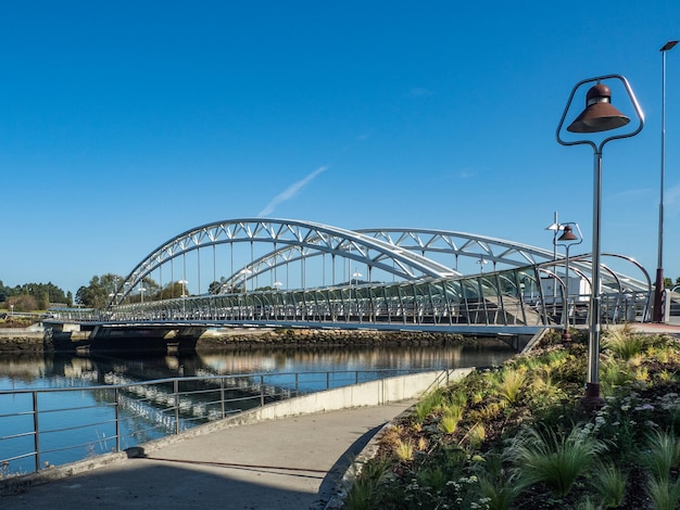 Foto brug over de rivier tegen een heldere blauwe hemel.