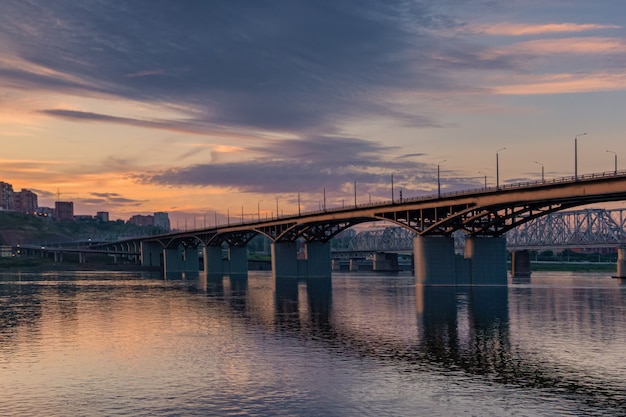 Brug over de Yenisei-rivier, avondzonsondergang. Krasnoyarsk, Rusland. panorama van de avond stad