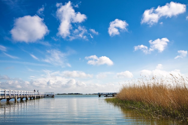 Brug over een rustig meer tegen een blauwe hemel.