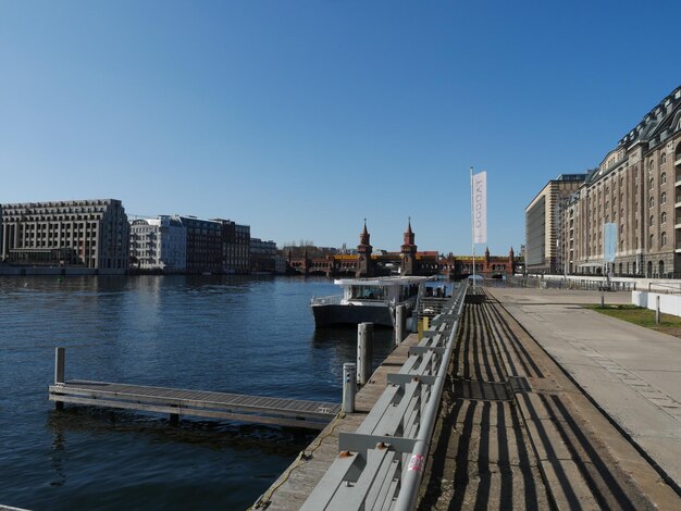 Brug over rivier in de stad tegen een heldere blauwe lucht