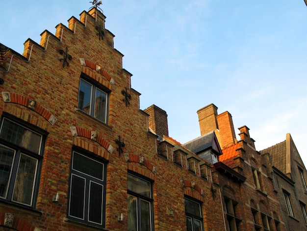 Bruges, Brugge, facades of ancient houses of an unusual shape against the blue sky, ancient house