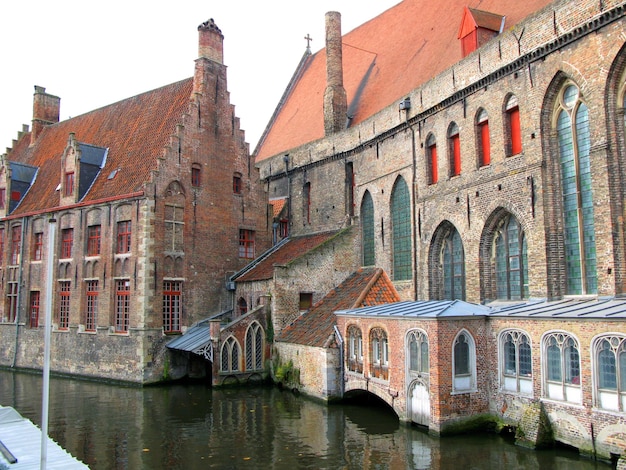 Brugge, Bruges typical street in the old town, old houses with tiled roofs, canal, autumn, Belgium.