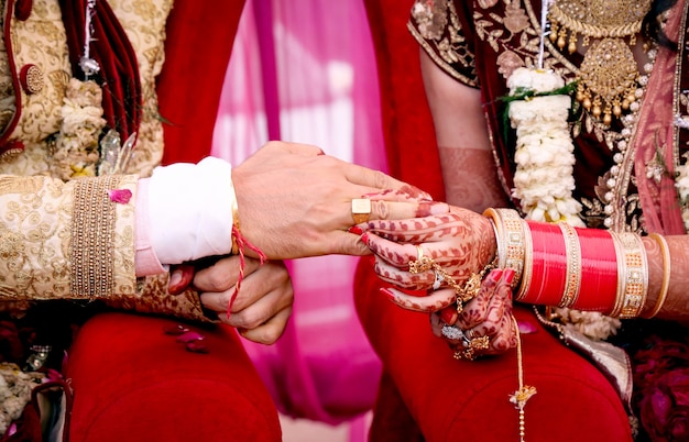 Bruid die een trouwring om de vinger van de bruidegom doet